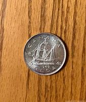 Reverse side of 1949 Canadian silver dollar showing canoe design and date