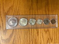 Reverse wildlife designs side of six-coin Centennial set in plastic holder