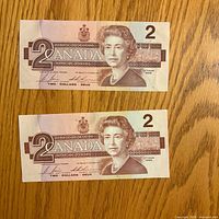 Front side of both $2 banknotes showing Queen Elizabeth II and denominations