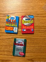 Front view of three sealed baseball card packs showing brand names and packaging
