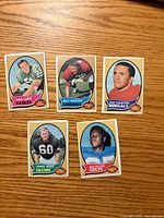 Fronts of five 1970 Topps football cards laid out on wood surface
