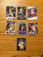 Fronts of all seven LeBron James cards displayed on wooden surface