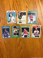 Fronts of all seven hockey cards laid out on wood surface