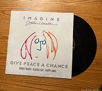 Front of picture sleeve and partially visible black vinyl record