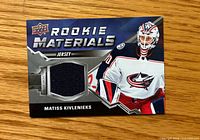 Front of card showing player image, Rookie Materials branding, and navy jersey swatch