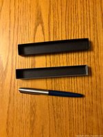 Parker fountain pen with separated case lid and base on wood surface