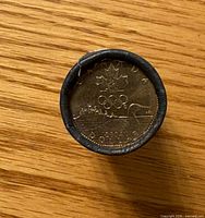 End view of roll displaying Olympic Lucky Loonie coin design