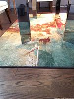 Rug close-up under glass table showing abstract pattern