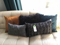 All five pillows grouped on sofa showing size and color variety