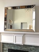 Front view of rectangular beveled mirror on wall showing full frame and reflective surface