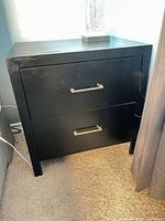 Front view of black two-drawer end table showing handles and overall construction
