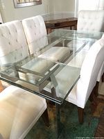 Glass dining table with chrome frame and chairs viewed from side