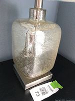 Close view of crackled mercury glass lamp base on brushed nickel platform