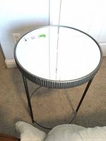 Full view of round side table with mirror top and metal frame