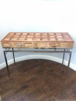 Full view of mixed wood console table on metal base