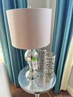 Lamp and two candleholders on side table