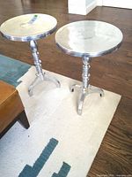 Two matching aluminum pedestal tables side by side