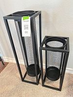 Both black metal mesh lanterns side by side showing size difference