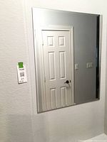 Full view of rectangular frameless mirror mounted on wall