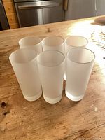 Six frosted glass highball tumblers standing on table