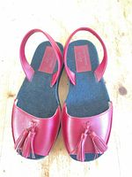 Top view of both sandals showing red leather uppers, tassels, slingback straps