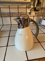 Front view of Starbucks insulated carafe on tiled counter