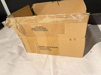 Closed cardboard box marked "Banker Lamp Shade"