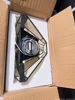 Back view of sconce in original box showing mounting plate and internal wiring