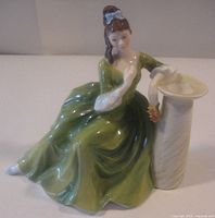 Front view of Royal Doulton Secret Thoughts figurine showing woman in green gown and pedestal