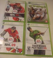 Front view of four Xbox 360 game cases: NHL 08, NHL 09, Top Spin 2, Tiger Woods PGA Tour 09