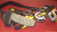 Full view of black and yellow hinged knee brace with straps and dial