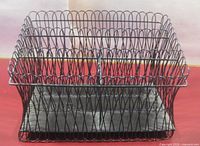Front view of black metal wire desk organizer showing compartments and base