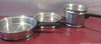 Three pans and double boiler displayed side by side