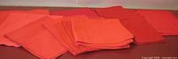 Stack and spread of red napkins showing color range