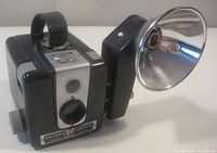 Front and side view of the Kodak Brownie Hawkeye camera with flash attached