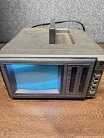 Front of GE Spacemaker TV showing powered-on CRT, control buttons and radio scale