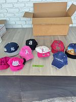 All nine baseball caps lined on table
