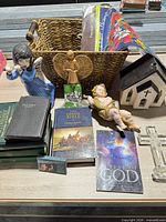 Group shot showing basket, books, figurines, church model and acrylic cross