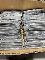 Open box showing large quantity of polybagged black phone cases