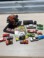 Group shot of engine model, carded sprint car and loose die-cast vehicles