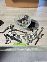 Lot overview with crystal vase, jewelry contents and spread of wristwatches