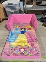 Chair unfolded to bed showing princess artwork