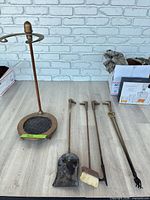 Full view of stand and four brass tools with duck head handles