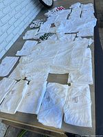 Overview of all folded and unfolded white T-shirts on table