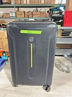 Front view showing ribbed black shell, yellow stripe, spinner wheels