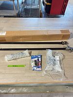 Pole sections, boxed packaging, flag packet, hardware bags on table
