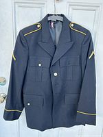 Front view of the dark navy US Army dress coat on hanger