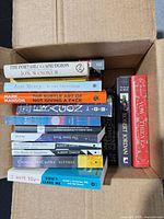 Books stacked in shipping box showing spines and two Robert Jordan hardcovers