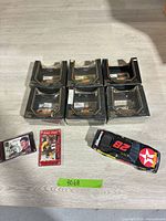 Lot overview with six boxed diecasts, one loose car, two trading cards
