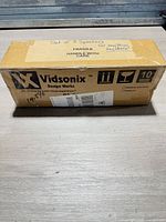 Top of sealed Vidsonix speaker box showing brand logo and set of 3 speakers note